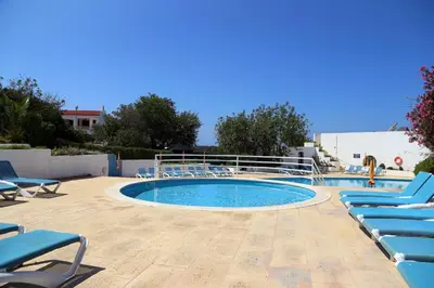 a swimming pool with blue chairs and a swimming pool at Sunset Pôr do sol in Galé