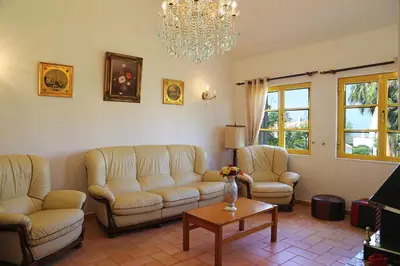 a living room with couches and a table and a chandelier at Sunset Pôr do sol in Galé