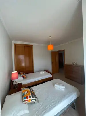 a room with two beds and a lamp in it at Apartamento Falésia c/ Piscina in Albufeira