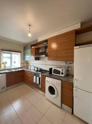 a kitchen with a washing machine and a microwave at Apartamento Falésia c/ Piscina in Albufeira