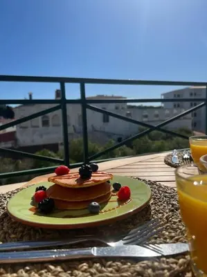 a cake on a table with a plate of fruit at Apartamento Falésia c/ Piscina in Albufeira