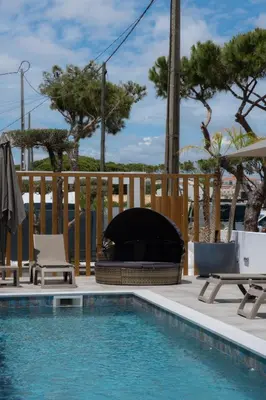 a swimming pool with a fire place next to a swimming pool at Ria Formosa Guest House in Faro