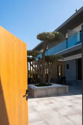 an open door in front of a building with trees at Ria Formosa Guest House in Faro