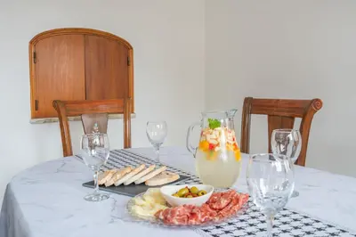 a table with a plate of food and wine glasses at Sunshine Holiday House in Quarteira