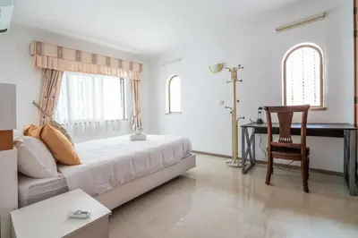 a bedroom with a bed and a desk and a chair at Sunshine Holiday House in Quarteira