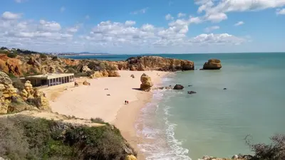 a view of a beach with rocks in the water at Albufeira Traditional Apartments IN VILLA in Albufeira