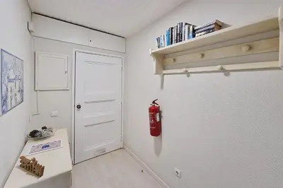 a room with a white refrigerator and a red fire extinguisher at Paradise full océan in Albufeira