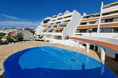 a large blue swimming pool in front of a building at Paradise full océan in Albufeira