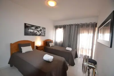 a hotel room with two beds and a window at T3 Olhos de Água in Albufeira