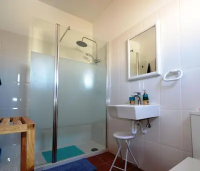 a bathroom with a shower and a sink and a mirror at T3 Olhos de Água in Albufeira