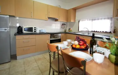 a kitchen with a table with a bowl of fruit on it at T3 Olhos de Água in Albufeira