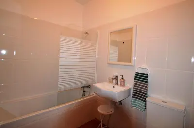 a white bathroom with a sink and a bath tub at T3 Olhos de Água in Albufeira