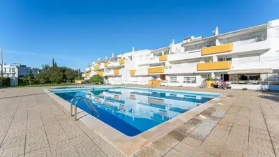 a swimming pool in front of a building at Design Top Floor With Balcony & Pool in Vilamoura