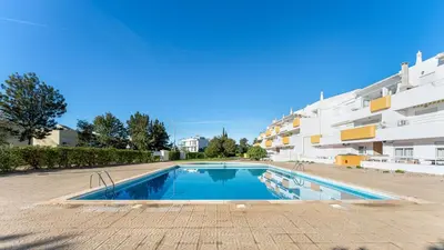 a swimming pool in front of a building at Design Top Floor With Balcony & Pool in Vilamoura