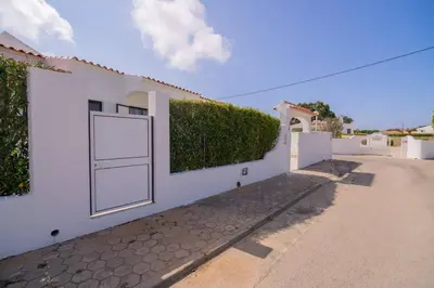 a white building with a white door and a hedge at Avo Isabel by Innkeeper in Guia