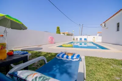a patio with a table and chairs and a swimming pool at Avo Isabel by Innkeeper in Guia