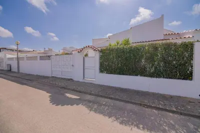 a white fence with a white door and a hedge at Avo Vitoria by Innkeeper in Guia