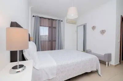 a white bedroom with a bed and a lamp at Avo Vitoria by Innkeeper in Guia