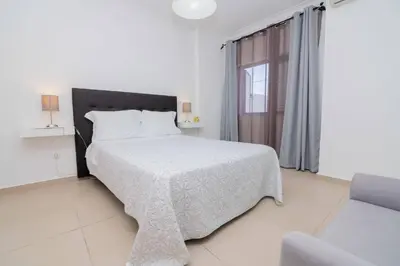 a white bedroom with a bed and a window at Avo Vitoria by Innkeeper in Guia