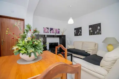 a living room with a table with a vase of flowers on it at Galé Catia by Innkeeper in Guia