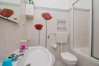 a bathroom with two red roses on the wall at Galé Igor by Innkeeper in Guia