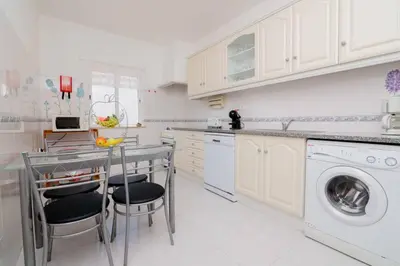 a white kitchen with a washing machine and a dishwasher at Galé Igor by Innkeeper in Guia