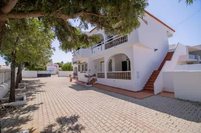 a large white building with stairs and trees at Galé Igor by Innkeeper in Guia