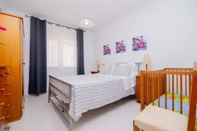 a bedroom with a bed and a crib at Galé Magda by Innkeeper in Guia