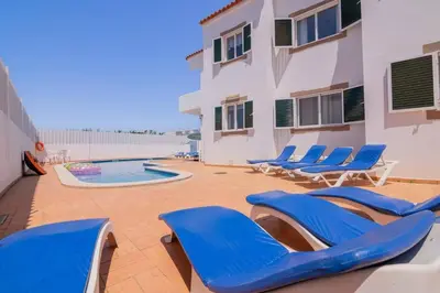 a patio with blue chairs and a swimming pool at Galé Magda by Innkeeper in Guia