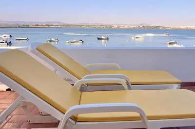 a row of chairs on a balcony with a view of the water at Beach House on Faro Island with a Dreamy Terrace and 7 Beds for the Perfect Escape in Faro