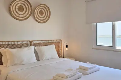 a bedroom with a white bed with towels on it at Beach House on Faro Island with a Dreamy Terrace and 7 Beds for the Perfect Escape in Faro
