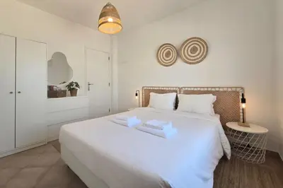 a bedroom with a large white bed with two white towels at Beach House on Faro Island with a Dreamy Terrace and 7 Beds for the Perfect Escape in Faro