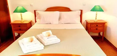 a bedroom with a bed with two towels on it at Corte Real Apartment AE - Sea & Old Town View in Albufeira