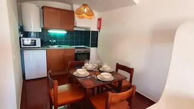 a kitchen with a table and chairs and a kitchen with a table and chairsktop at Bright apartment with sea view in Albufeira - 67 m² + pool in Albufeira