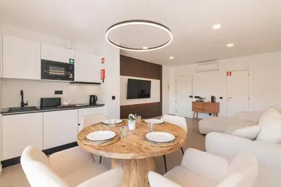 a kitchen and living room with a table and chairs at Apartamento em Albufeira - Condomínio com Piscina in Albufeira