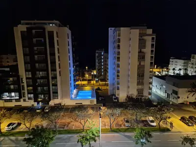 a view of two tall buildings at night at Quarteira-Mar in Quarteira