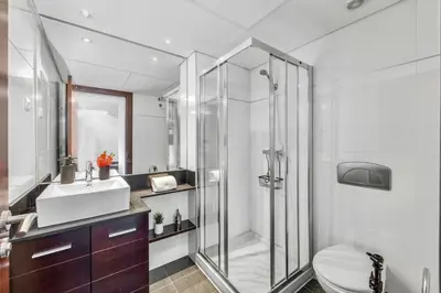 a bathroom with a shower and a toilet and a sink at Central Algarve Duplex Retreat with Garden & Pool in Quarteira