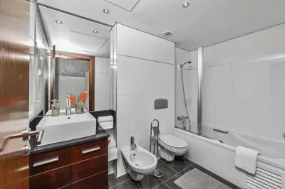 a bathroom with a sink and a toilet and a shower at Central Algarve Duplex Retreat with Garden & Pool in Quarteira