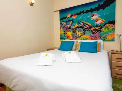 a bedroom with a white bed with a painting on the wall at Vilamoura Marina Apartment by Stay ici Algarve Holiday Rental in Quarteira