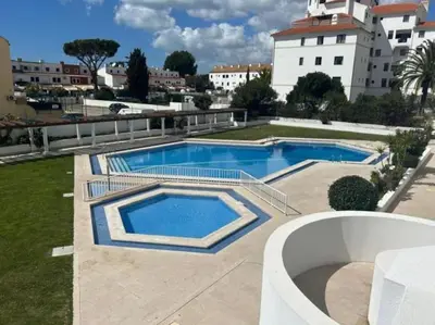 a swimming pool in a yard next to a building at Vilamoura Marina Apartment by Stay ici Algarve Holiday Rental in Quarteira