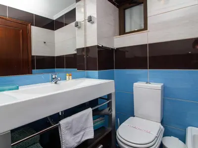 a bathroom with a sink and a toilet and a mirror at Vilamoura Marina Apartment by Stay ici Algarve Holiday Rental in Quarteira