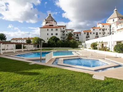 a pool in front of a large white building at Vilamoura Marina Apartment by Stay ici Algarve Holiday Rental in Quarteira
