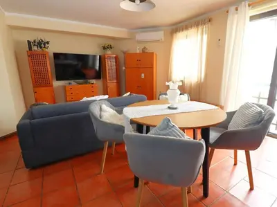a living room with a couch and a table and chairs at Vilamoura Marina Apartment by Stay ici Algarve Holiday Rental in Quarteira