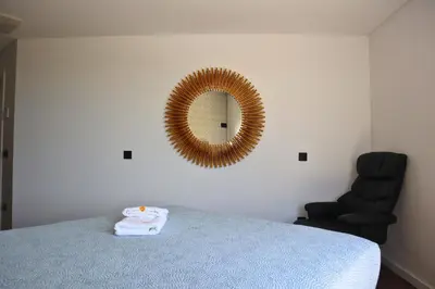 a bedroom with a bed with a mirror and a chair at Sea la Vie House by Stay ici Algarve Holiday Rental in Albufeira