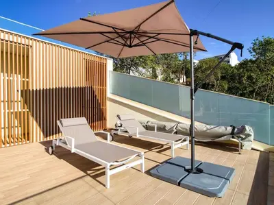 a patio with two chairs and an umbrella at Sea la Vie House by Stay ici Algarve Holiday Rental in Albufeira