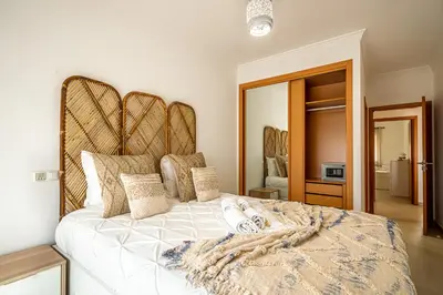 a bedroom with a large bed with a large headboard at BeGuest Summer Breeze in Vale Parra in Galé
