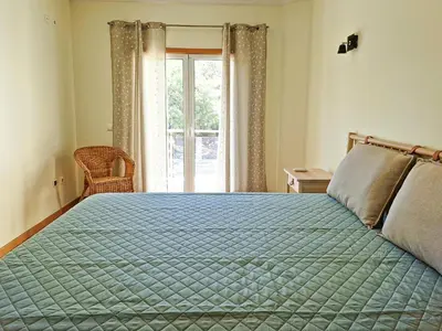 a bedroom with a bed with a green comforter and a window at Villa ENCOSTA VISTA SALGADOS - BY BEDZY in Guia