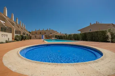 a large blue pool in the middle of a courtyard at Rosal Beach House in Albufeira