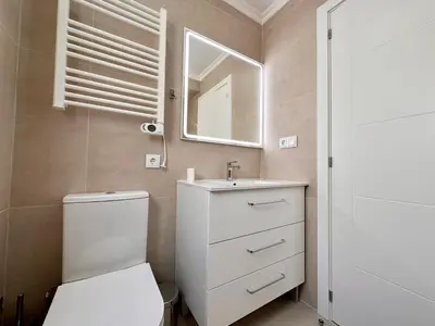 a bathroom with a toilet and a sink and a mirror at Holiday Apartment Albufeira in Albufeira