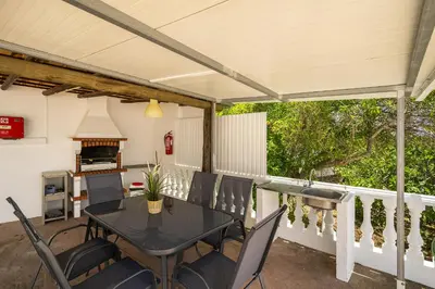 a patio with a table and chairs and a fireplace at Casa Solar in Guia